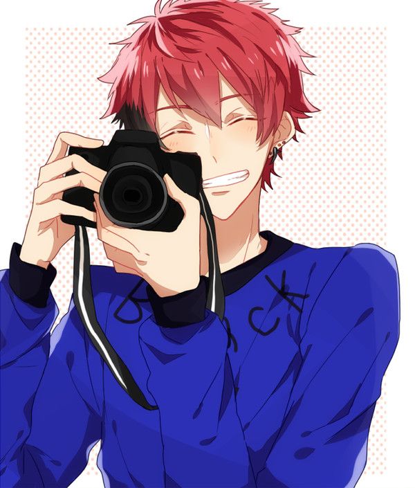 a man with red hair holding a camera up to his face and taking a photo