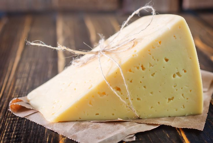 a piece of cheese sitting on top of a wooden table