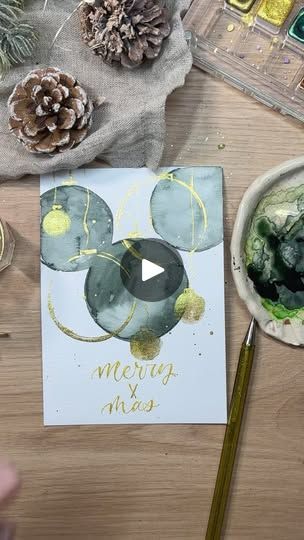 a table topped with pine cones and other items next to a card that says merry xmas