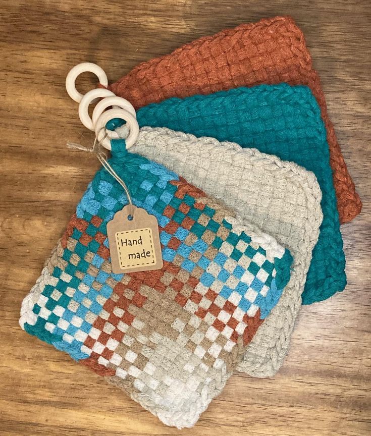 four crocheted pouches with tags on them