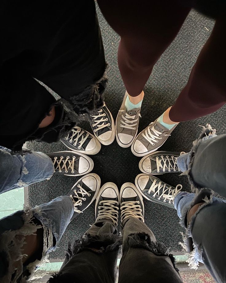 four people standing in a circle with their legs crossed