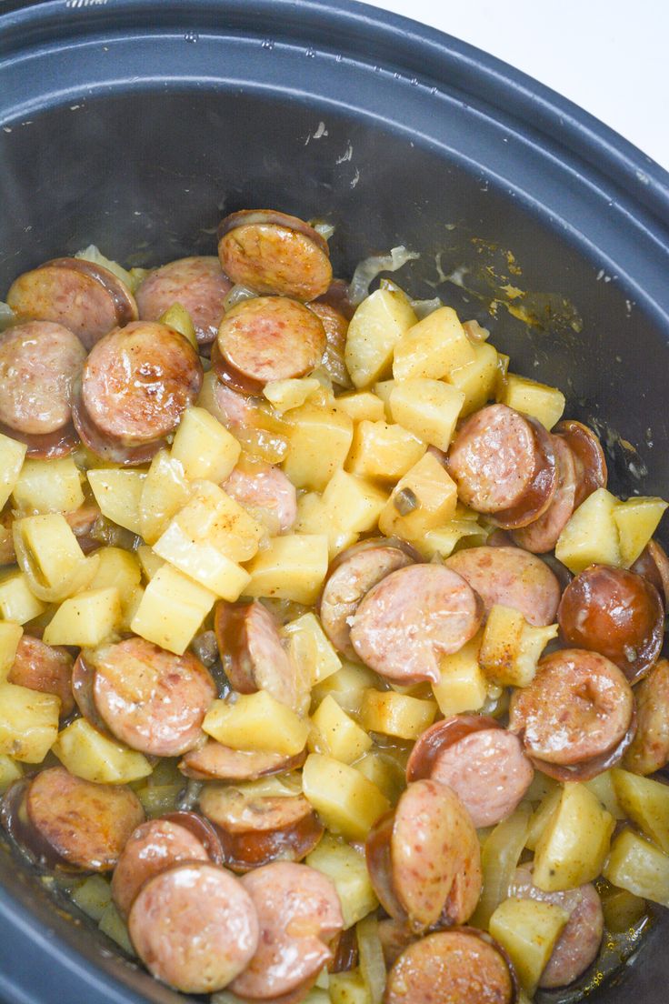 a crock pot filled with sausage and potatoes