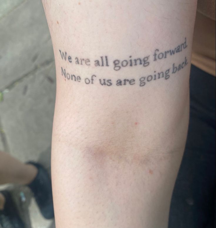 a person with a tattoo saying we are all going forward none of us are going back