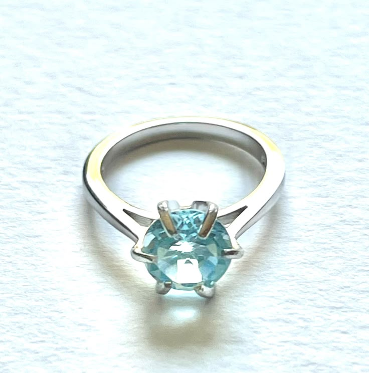 A beautiful sky blue topaz is mounted in a 925 silver claw setting. It measures 8mm in diameter. The ring is a small size K/L in UK sizing. The colour is absolutely lovely and it is beautifully cut. Blue Aquamarine Solitaire Ring, Light Blue Brilliant Cut Topaz Ring As Gift, Light Blue Brilliant Cut Topaz Ring For Gift, Light Blue Brilliant Cut Topaz Ring Gift, Solitaire Aquamarine Ring Round Cut, Light Blue Topaz Ring In Sterling Silver, Light Blue Ring With Prong Setting, Blue Topaz Solitaire Ring With Round Band, Blue Topaz Solitaire Ring Round Cut