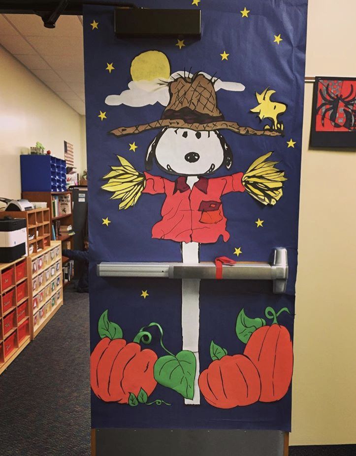 a door decorated with an image of a scarecrow and pumpkins in the background