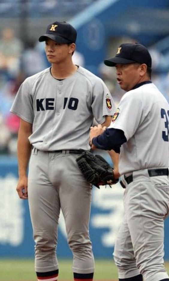 two baseball players standing next to each other on a field