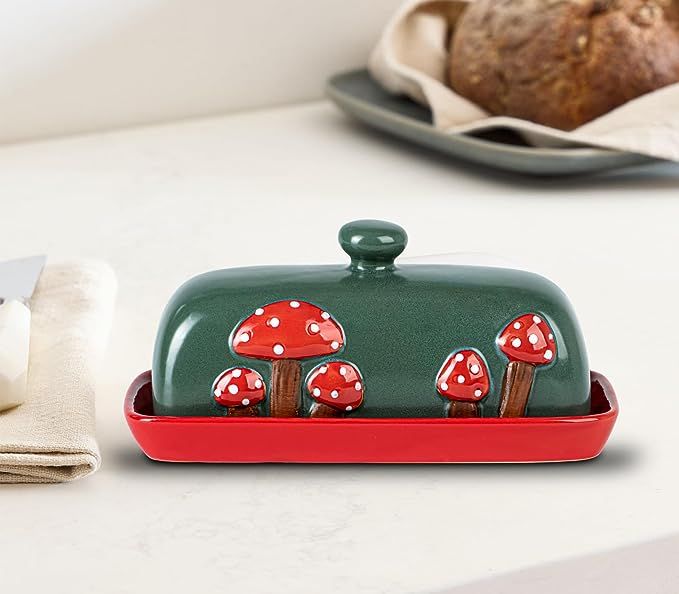 a green and red dish with mushrooms on it sitting next to a loaf of bread