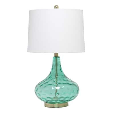 a green glass table lamp with a white shade