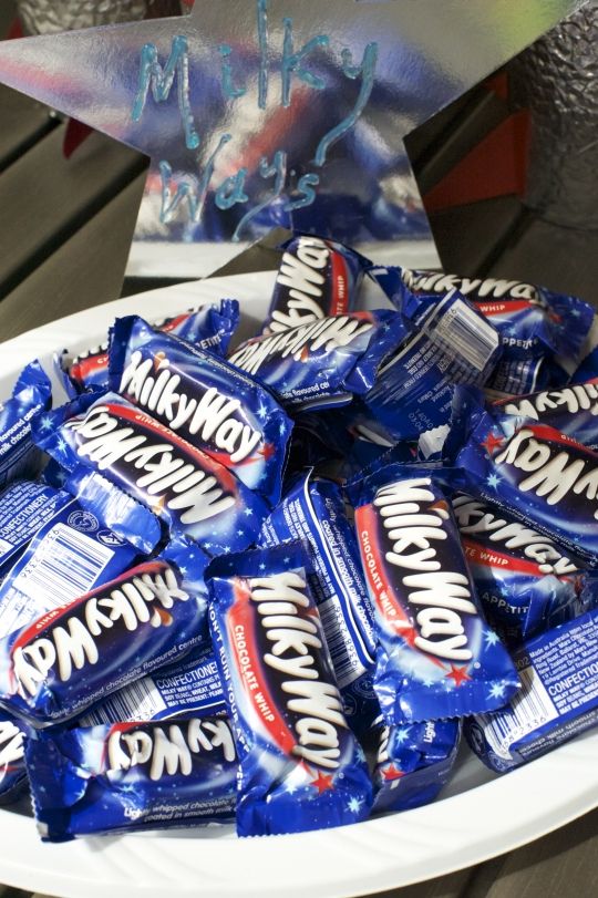 a white plate topped with lots of blue and red candy bar wrapped in wrappers