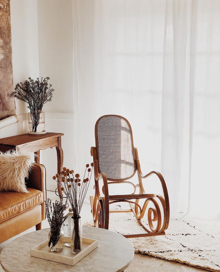 a living room filled with furniture and flowers in vases on top of a table