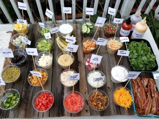 a table topped with lots of different types of food on top of wooden trays