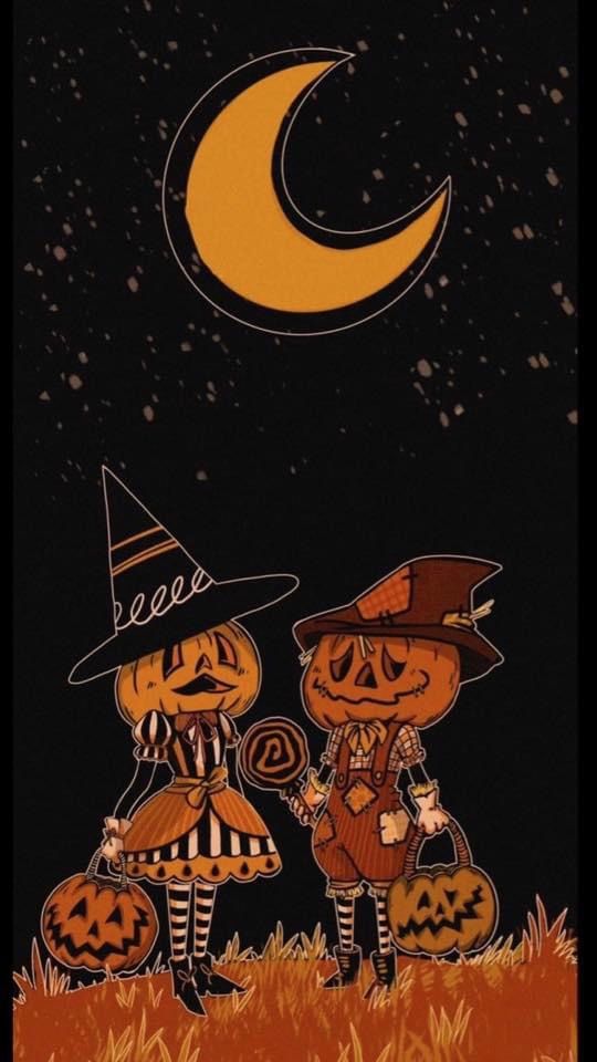 two pumpkins dressed as witches in front of the moon