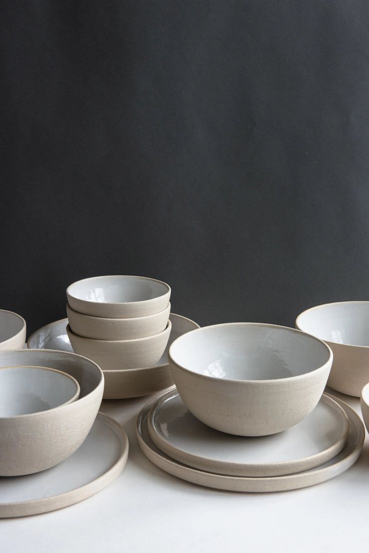 a table topped with white plates and bowls