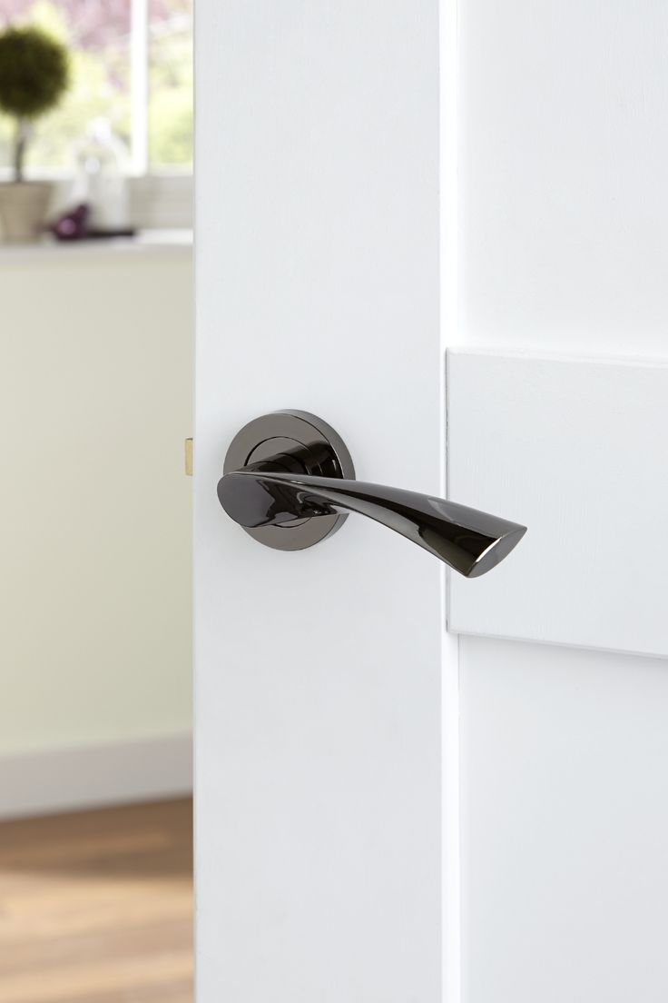 an open door with a black handle on the front and side of it in a white room