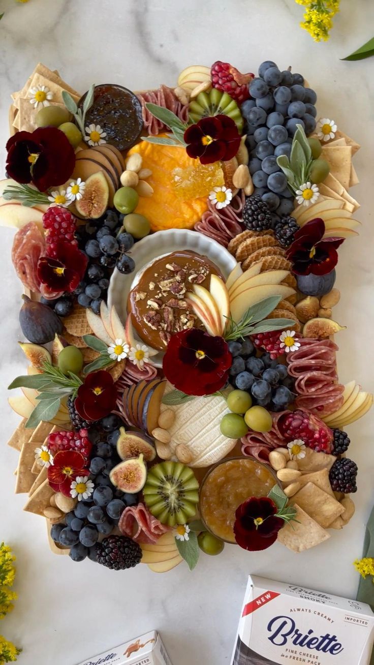 a platter filled with cheese, fruit and crackers