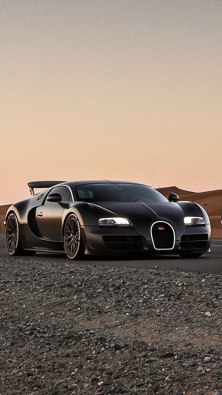 two bugatti cars are parked in the desert