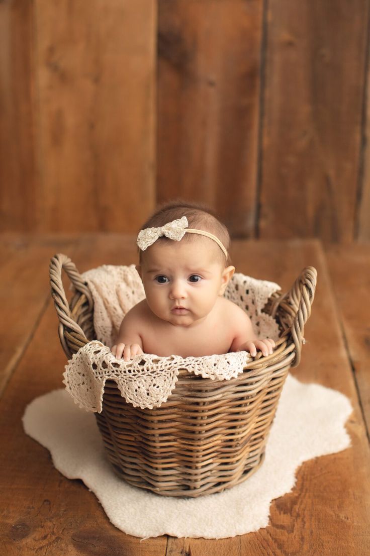 a baby sitting in a basket on top of a table