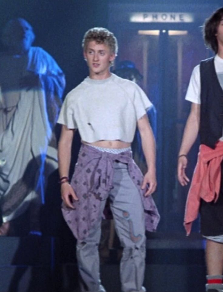 two young men walking down a runway at a fashion show