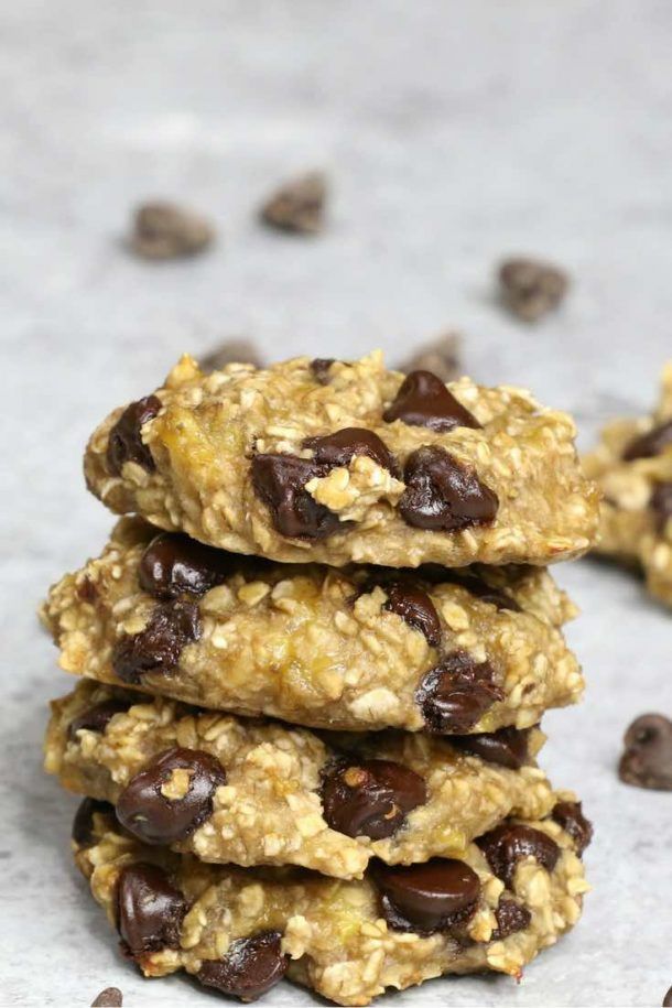 chocolate chip oatmeal cookies stacked on top of each other in front of scattered chocolate chips