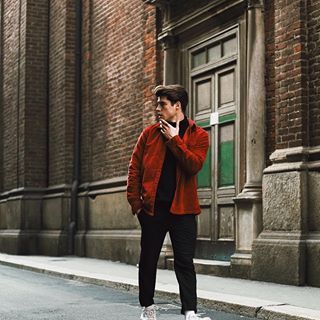 a man standing on the street while looking at his cell phone