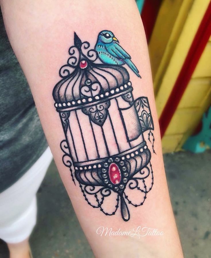 a bird in a cage tattoo on the arm