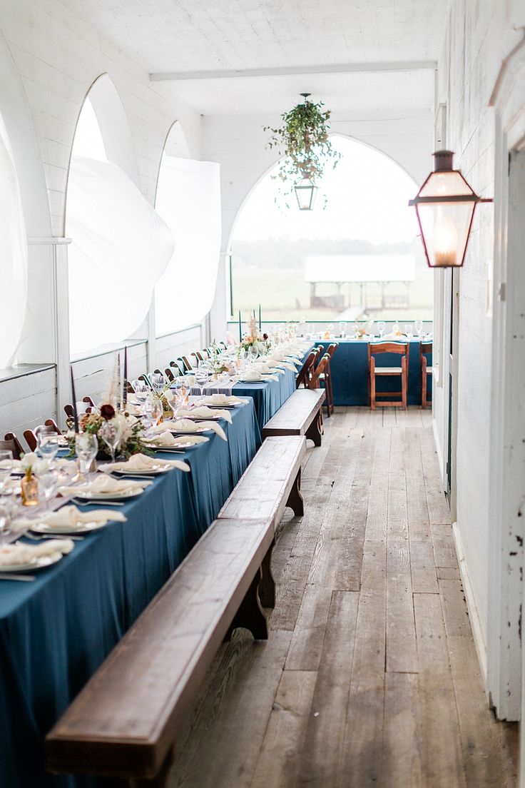 a long table is set up with plates and silverware for a formal dinner in an old building