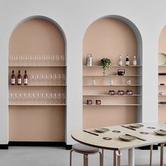 an empty dining room with pink walls and shelves