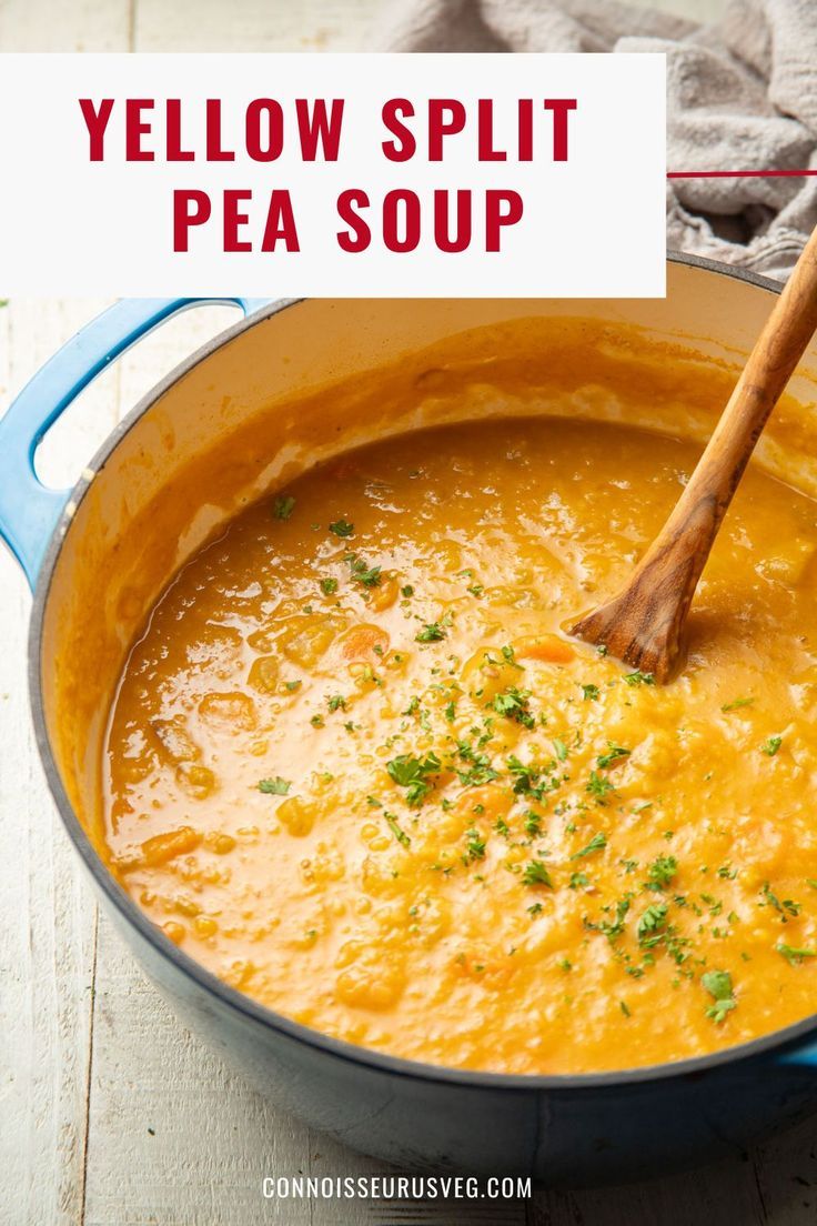 yellow split pea soup in a blue pot with a wooden spoon and napkin on the side