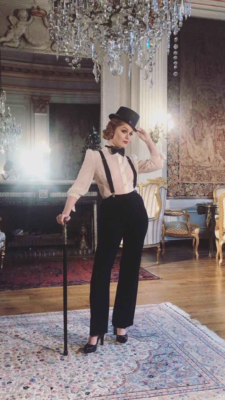 a woman standing in front of a chandelier holding a cane with her hand