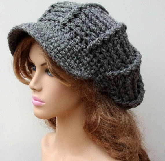 a mannequin head wearing a gray crochet newsboy hat on top of a wig