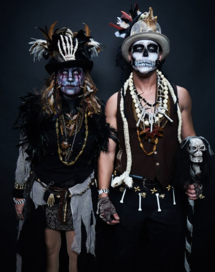 two men dressed in costumes standing next to each other with their faces painted white and black