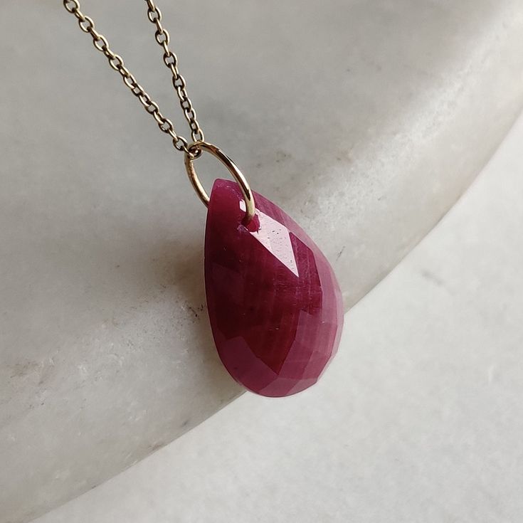 >>The pendant is made from Solid 14K Yellow Gold. Gemstone used is absolutely natural and ethically sourced.  >>Natural Ruby Precious Stone in pear shape is drilled with a minimalist gold bail with utmost precision. >>This is a minimalist design and is absolutely hassle-free and everyday jewelry. Gem: Ruby Gem shape: Pear checker cut Gem size: 12x20mm Gem weight: 10.80 cts Gold weight : 0.10 gram Gross weight : 2.26 gram The Gold purity is guaranteed and it comes with authentic 14K gold hallmark Yellow Gold Ruby Teardrop Necklace, Yellow Gold Teardrop Ruby Necklace, Teardrop Ruby Necklace In Yellow Gold, Fine Jewelry Ruby Briolette Necklace, Ruby Briolette Necklace In Fine Jewelry Style, Ruby Briolette Fine Jewelry Necklace, Fine Jewelry Ruby Teardrop Necklace, Ruby Teardrop Necklace In Fine Jewelry Style, Ruby Teardrop Necklace Fine Jewelry