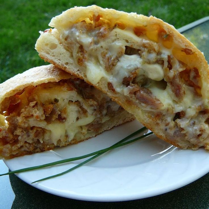 two pieces of pizza sitting on top of a white plate next to each other in the grass