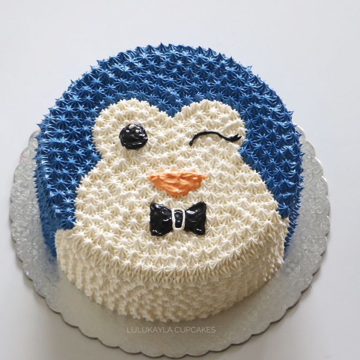 there is a cake that looks like a penguin on top of the cake, with blue and white icing