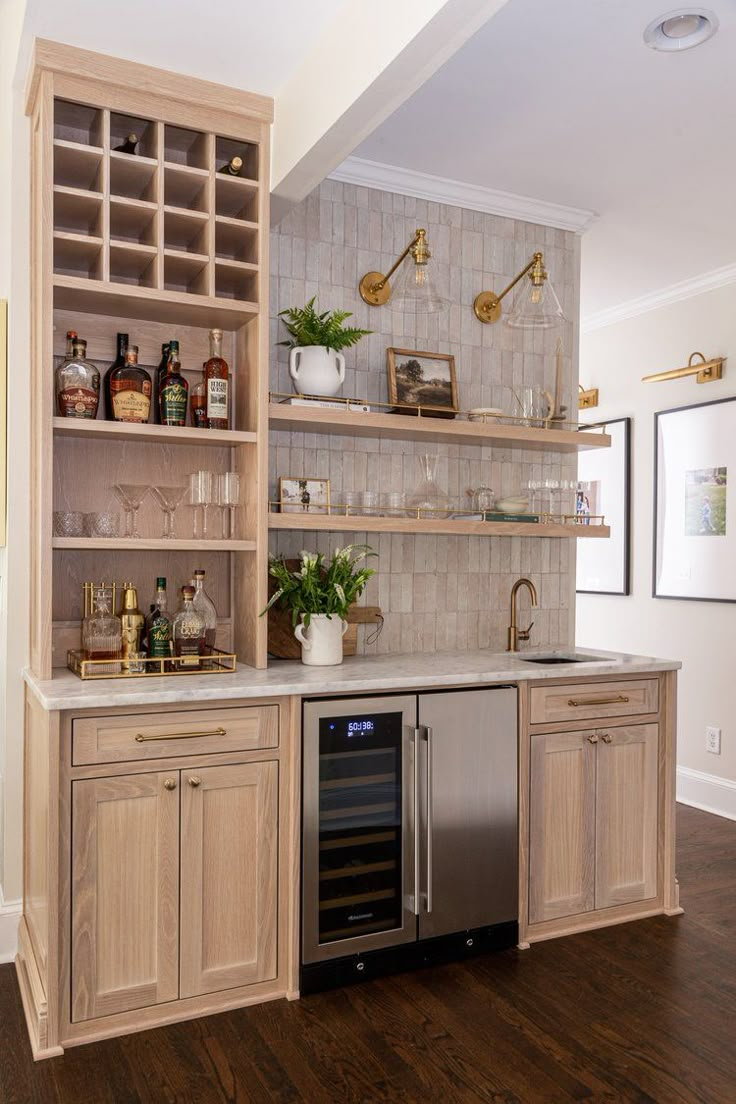 a kitchen with wooden cabinets and shelves filled with bottles, wine glasses and other items