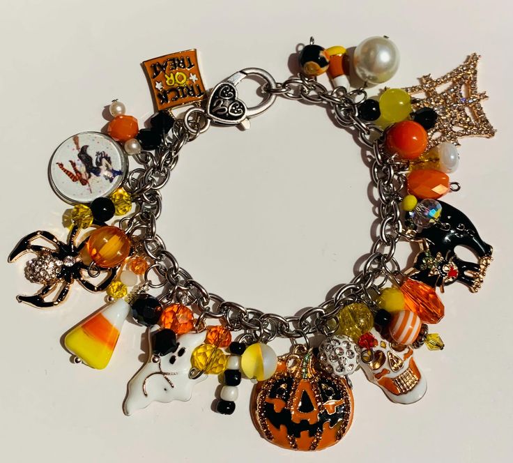 a charm bracelet with halloween charms on it's sides, including pumpkins, jack - o - lanterns and more