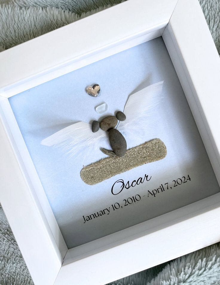 a baby's first christmas ornament is displayed in a white box frame