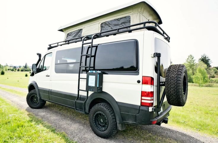 a white van parked on the side of a road with a roof tent attached to it