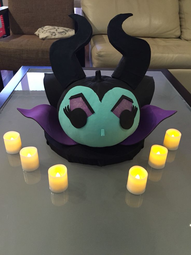 a table topped with candles and a monster mask