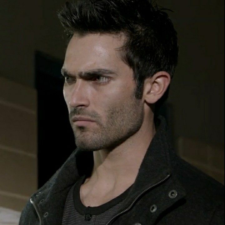 a close up of a person wearing a jacket and looking off to the side with a serious look on his face