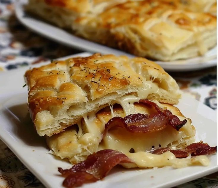 two white plates with different types of food on them and one has cheese and bacon