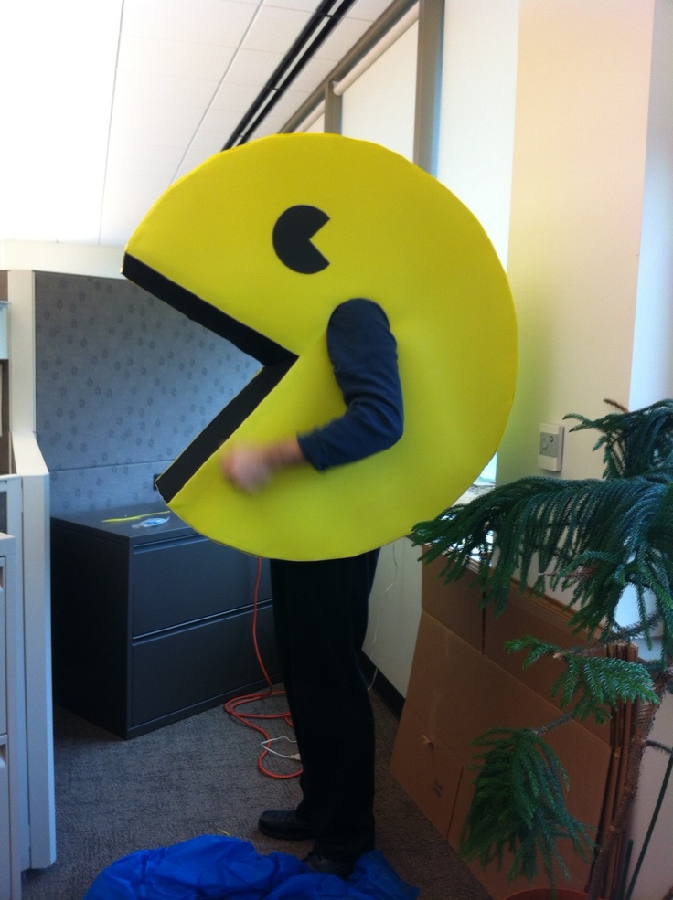 a man holding up a large yellow smiley face sign