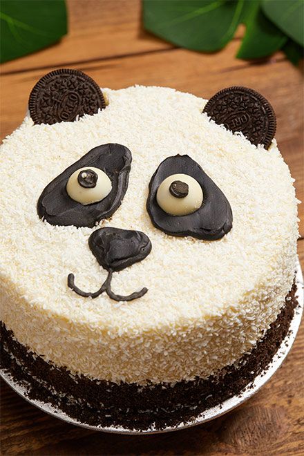 a panda bear cake sitting on top of a wooden table