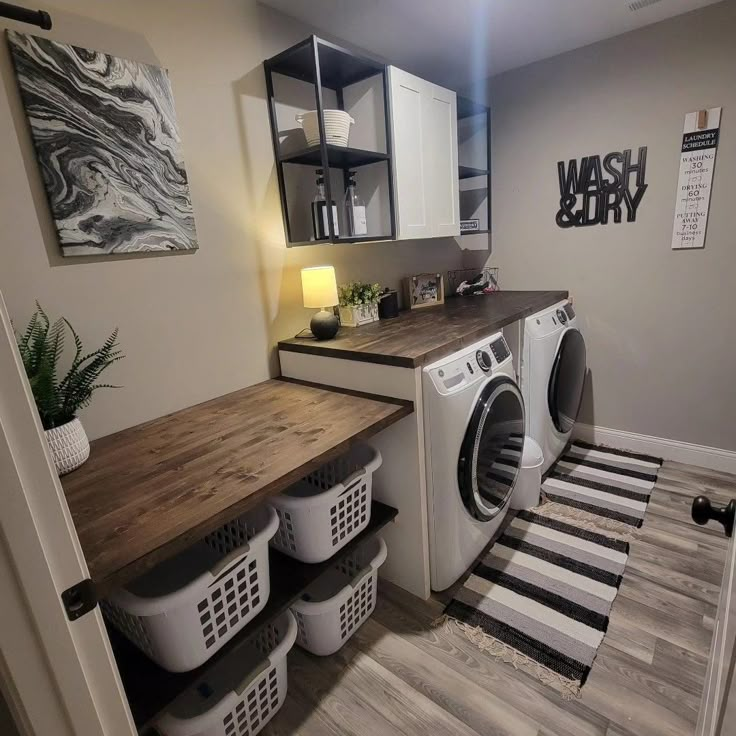 a washer and dryer sitting in a room next to a counter with baskets on it