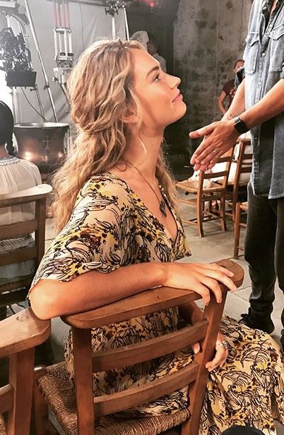 a woman sitting on top of a wooden chair