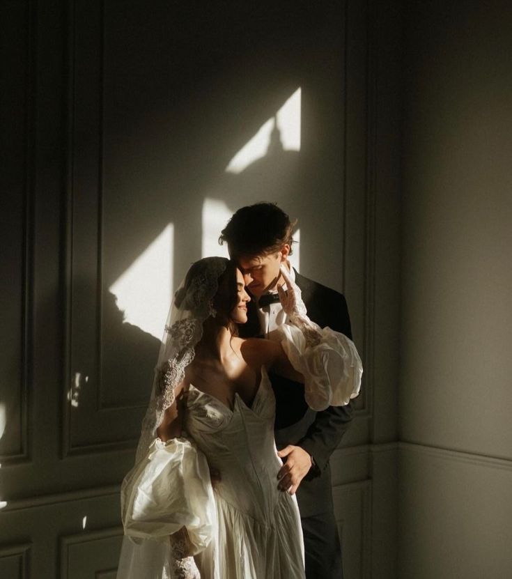 a bride and groom standing in the sunlight