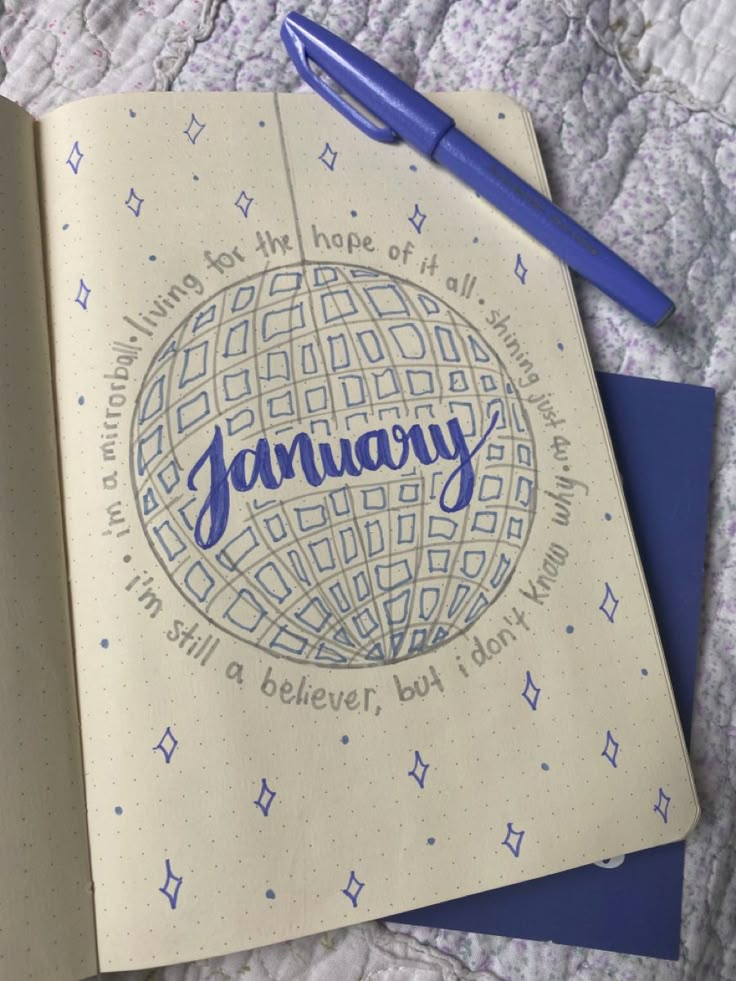 an open notebook with the word january written on it and a pen next to it