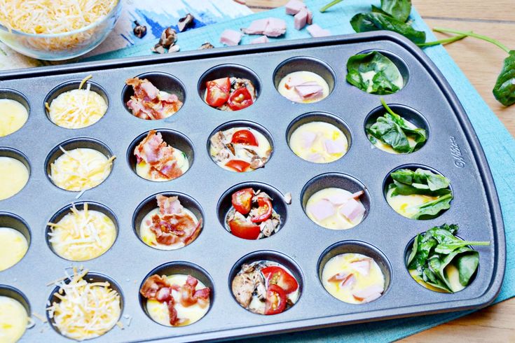 a muffin tin filled with lots of different types of food on top of a table