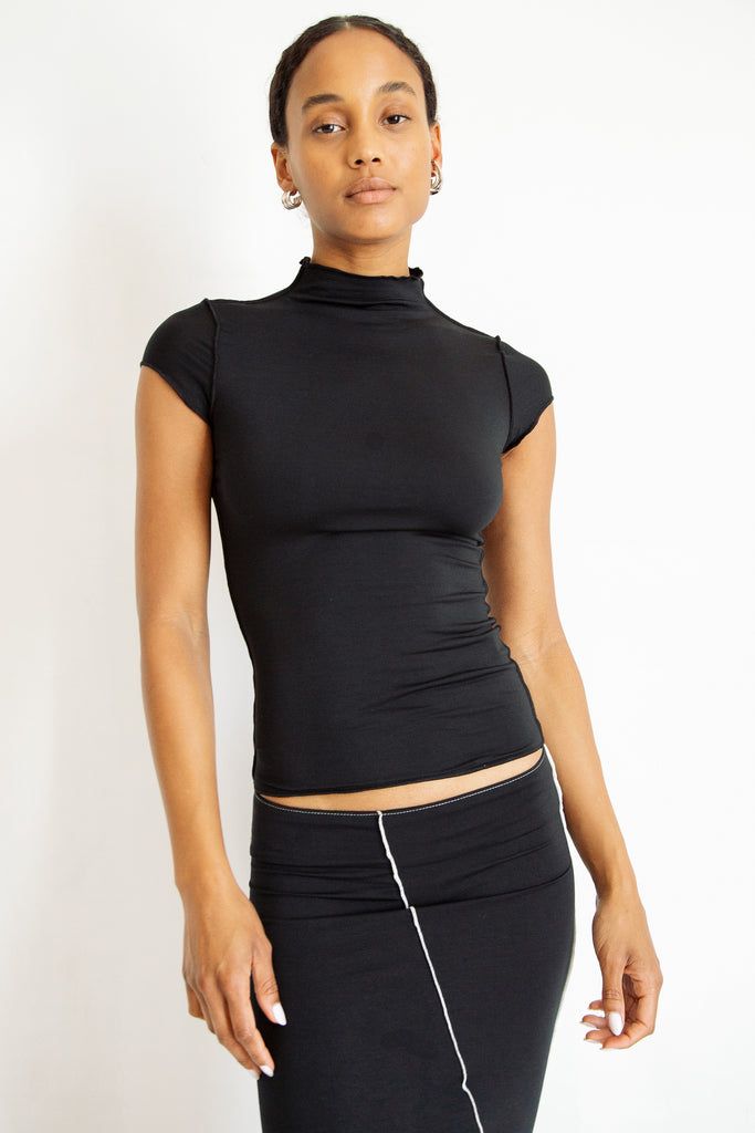 Versatile Black Second-skin Tops, Versatile Fitted Tops For Layering, Black 4-way Stretch Tops For Spring, Solid Stretch Elastane Top, Summer Mock Neck Turtleneck Top For Layering, Casual Mock Neck Top In Solid Color, Casual Mock Neck Top, Sleek Fitted Tops For Layering, High Neck Athleisure Top