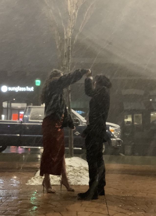 two people standing in front of a fountain with their hands on each other's heads